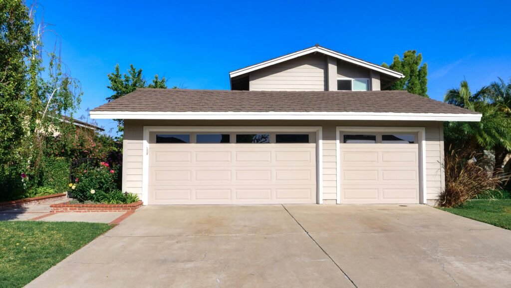 Exterior view of a cozy suburban house with a double garage, perfect for families.